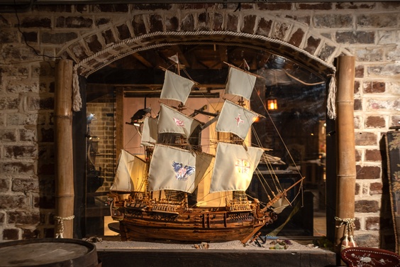 A lifelike wax figure of a pirate in a themed exhibit at the Savannah Pirates and Treasure Museum.