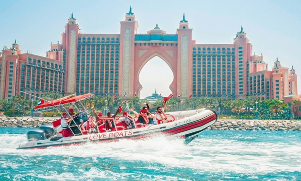 Speed boat cruising past iconic Dubai landmarks like Burj Al Arab and Atlantis The Palm