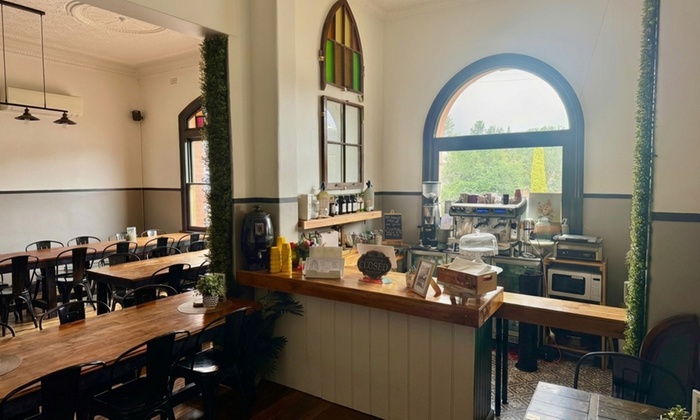 A beautifully set dining table with two main courses, sides, and glasses of wine, ready for a delicious meal.