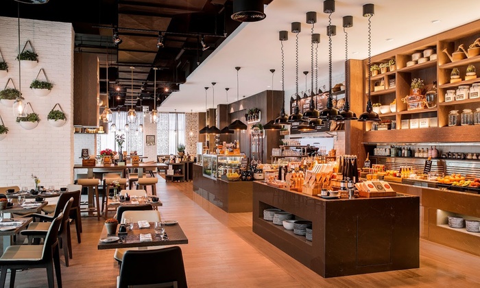 A vibrant spread of international buffet dishes including mixed grill, desserts, and various main courses at Café 302's Iftar.