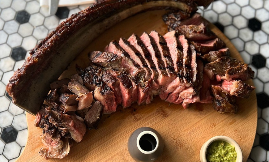 Image 1: Tomahawk steak, sides, and wine