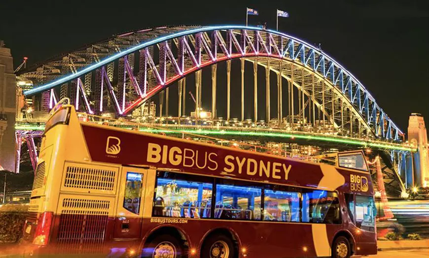 Image 1: Experience Sydney’s Landmarks Illuminated on an Open-Top Bus Tour