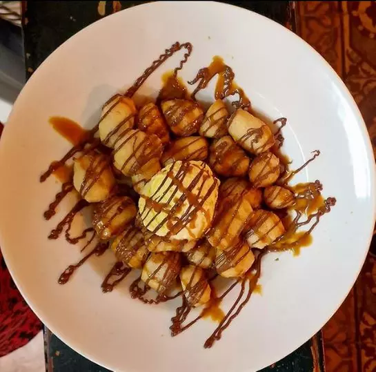 Menú venezolano con arepas, entrantes y pizza frita con helado