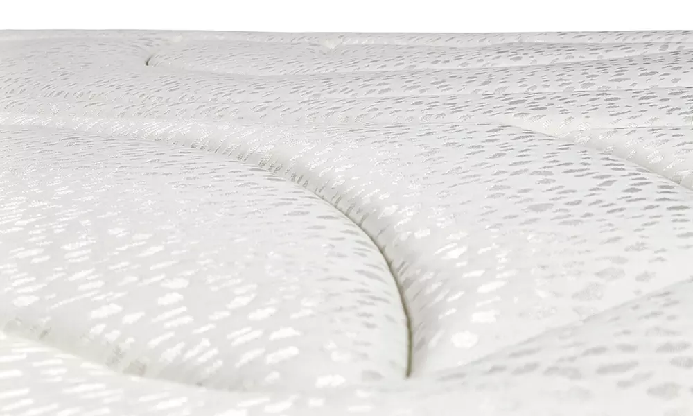 Canapé tapizado en polipiel de color blanco, con colchón y almohada