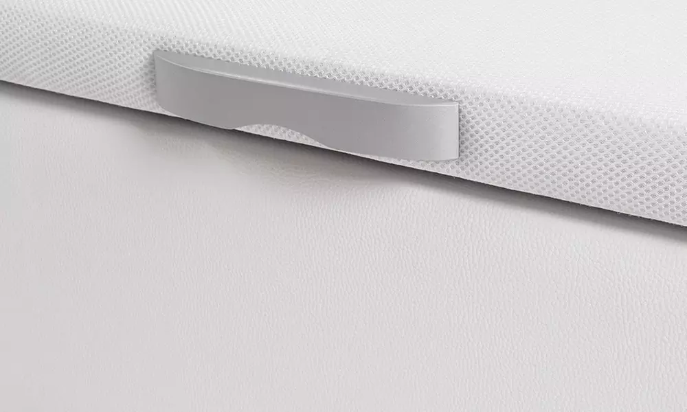 Canapé tapizado en polipiel de color blanco, con colchón y almohada