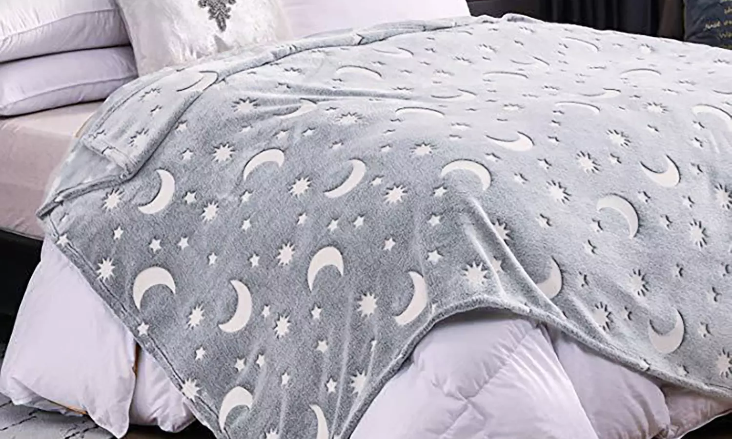 Kuscheldecke mit leuchtendem Stern- und Mond-Muster