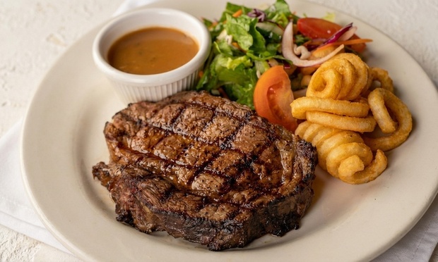 Delicious three-course meal featuring prime rib, chicken parmigiana, garlic bread, dessert, and drinks.