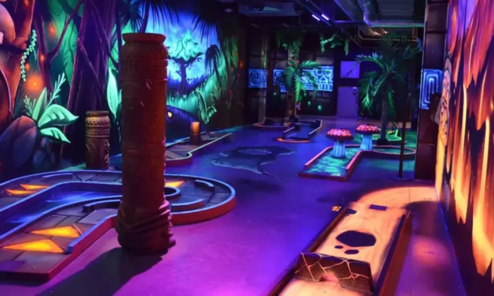 Mini-golf en famille sur un parcours lumineux