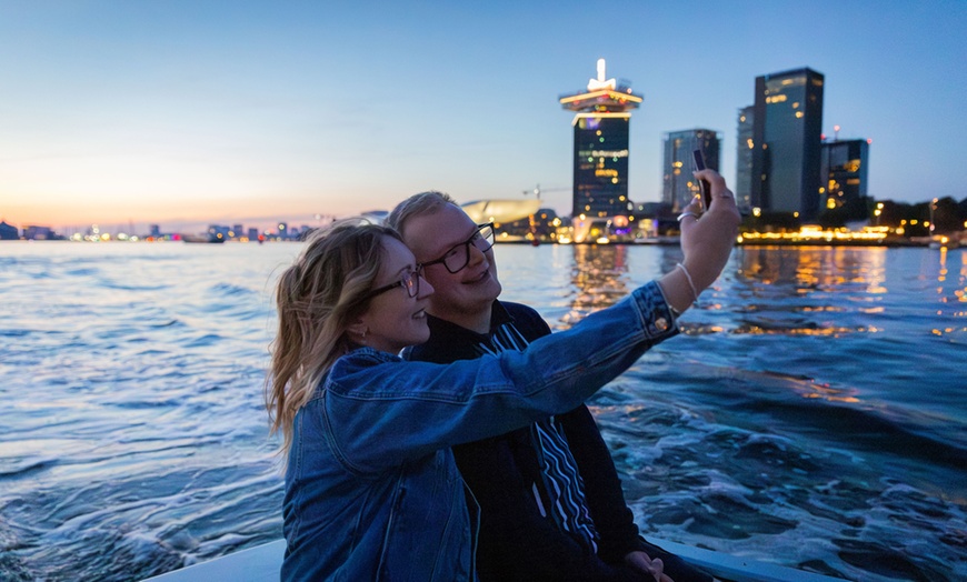 Image 24: Grachten vol lichtjes en legendes: een avondcruise door Amsterdam