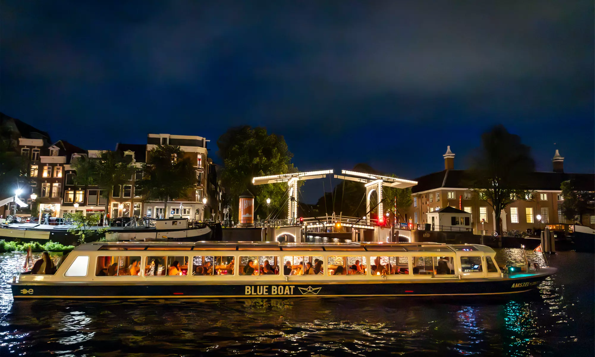 Grachten vol lichtjes en legendes: een avondcruise door Amsterdam