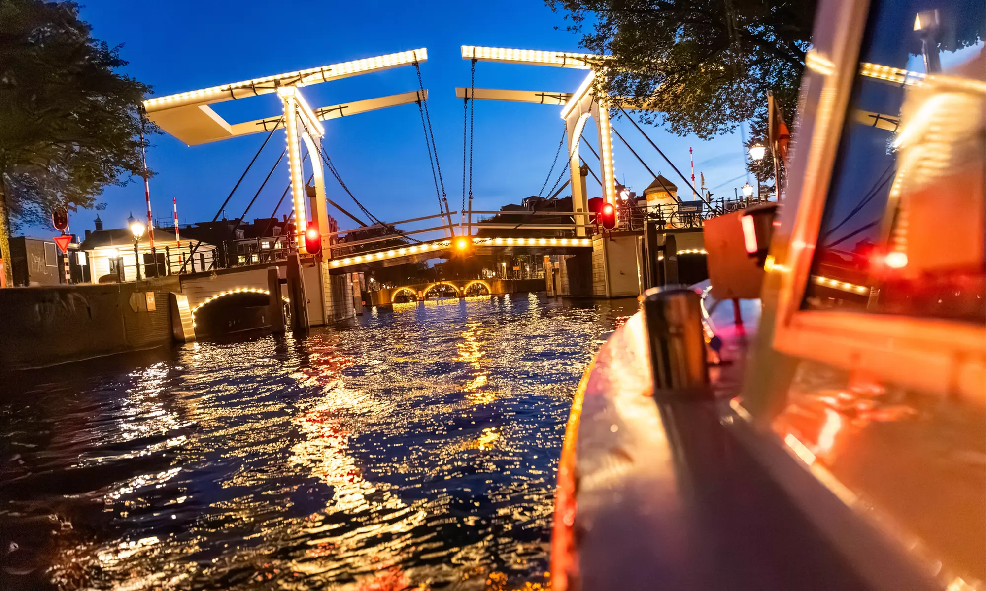 Grachten vol lichtjes en legendes: een avondcruise door Amsterdam