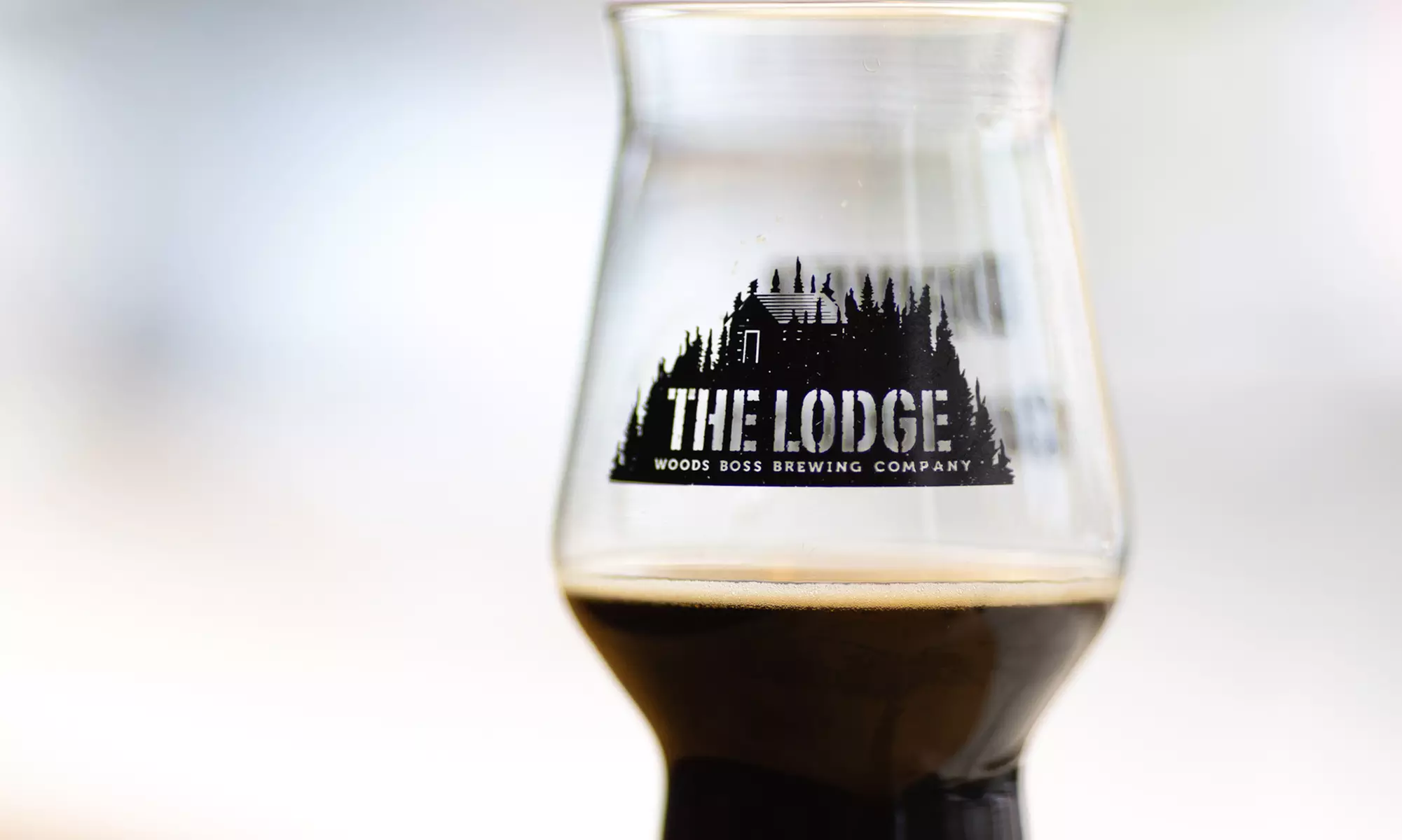 Crowler, Pint, Koozie & Sunglasses for One, Two or Four from Woods Boss Brewing (Up to 40% Off) - Primary Image