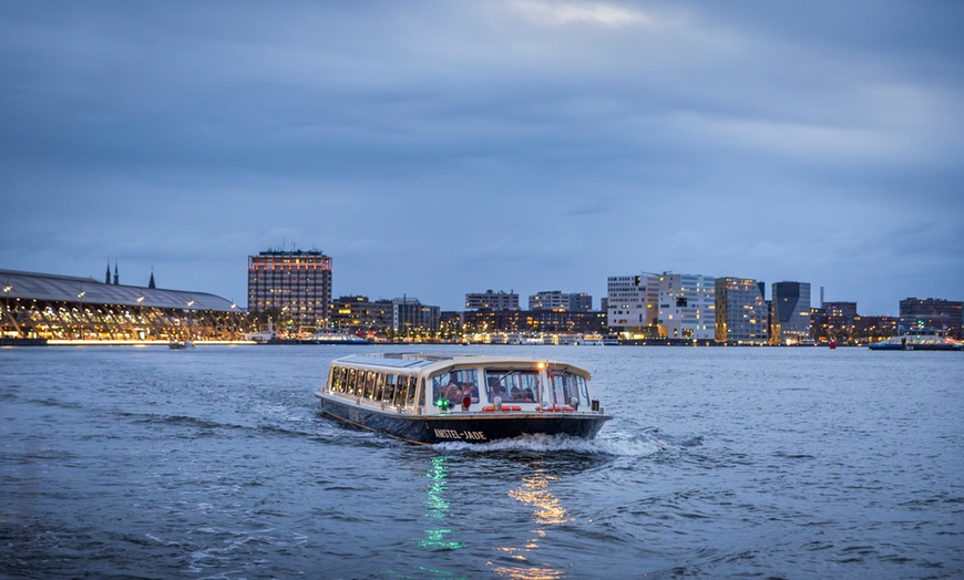 Image 1: Grachten vol lichtjes en legendes: een avondcruise door Amsterdam