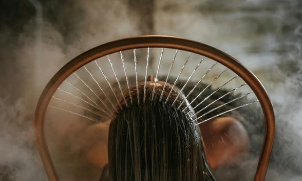 A person receiving a soothing head spa treatment with a facial mask applied, promoting relaxation and skin rejuvenation