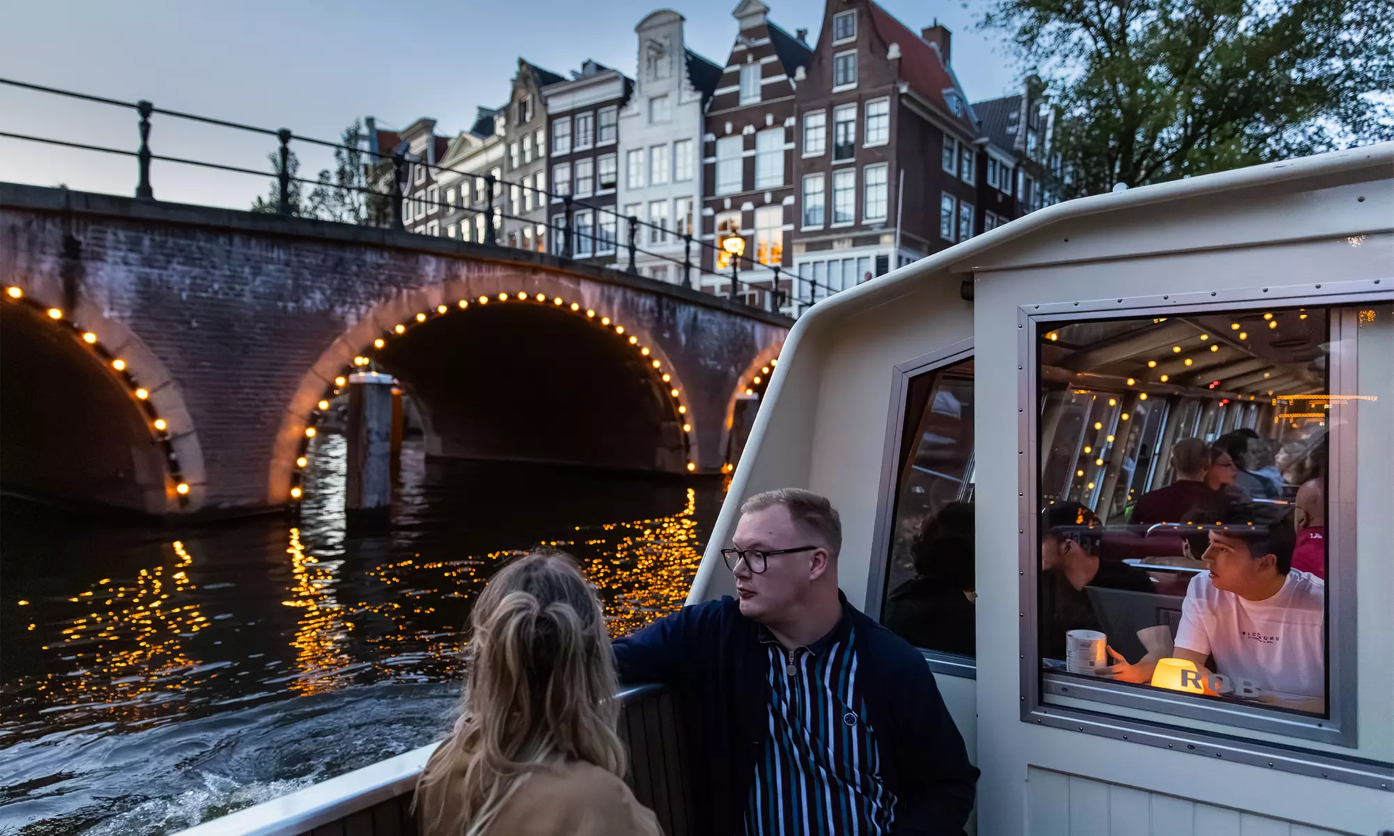 Grachten vol lichtjes en legendes: een avondcruise door Amsterdam