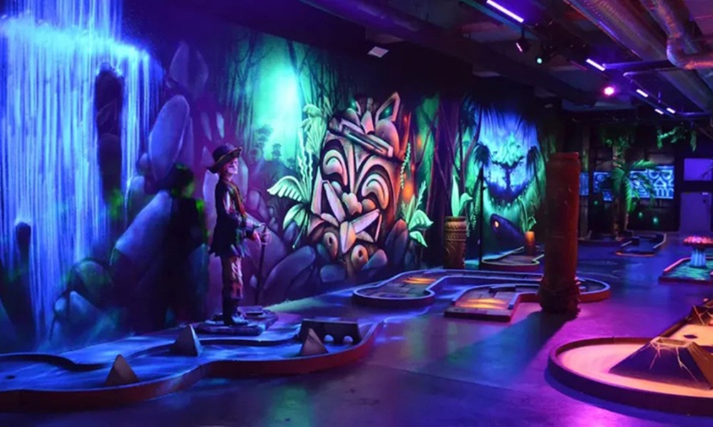 Mini-golf en famille sur un parcours lumineux