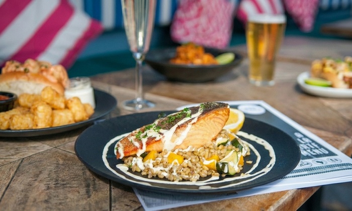 Interior view of a 1920s speakeasy bar with guests, showcasing vintage decor and a vibrant atmosphere.