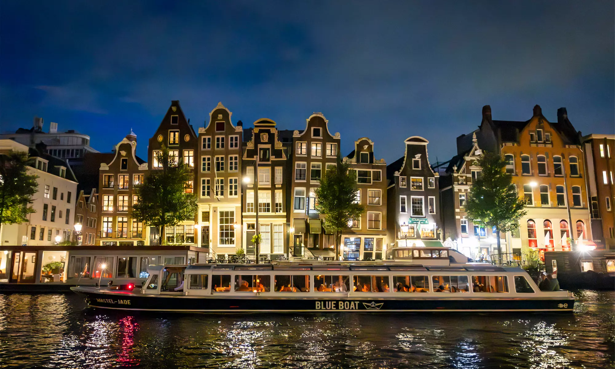 Grachten vol lichtjes en legendes: een avondcruise door Amsterdam