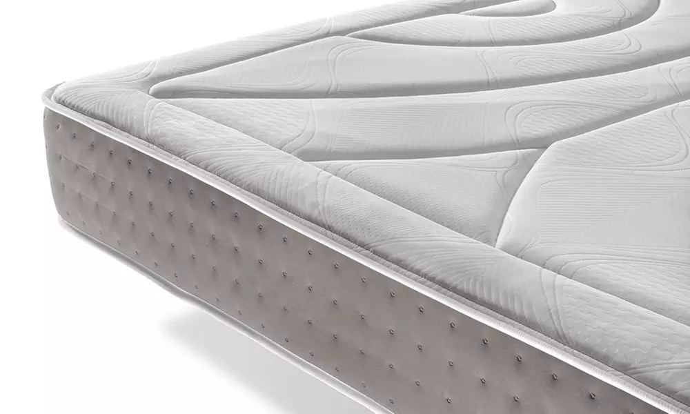 Canapé tapizado en polipiel de color blanco, con colchón y almohada