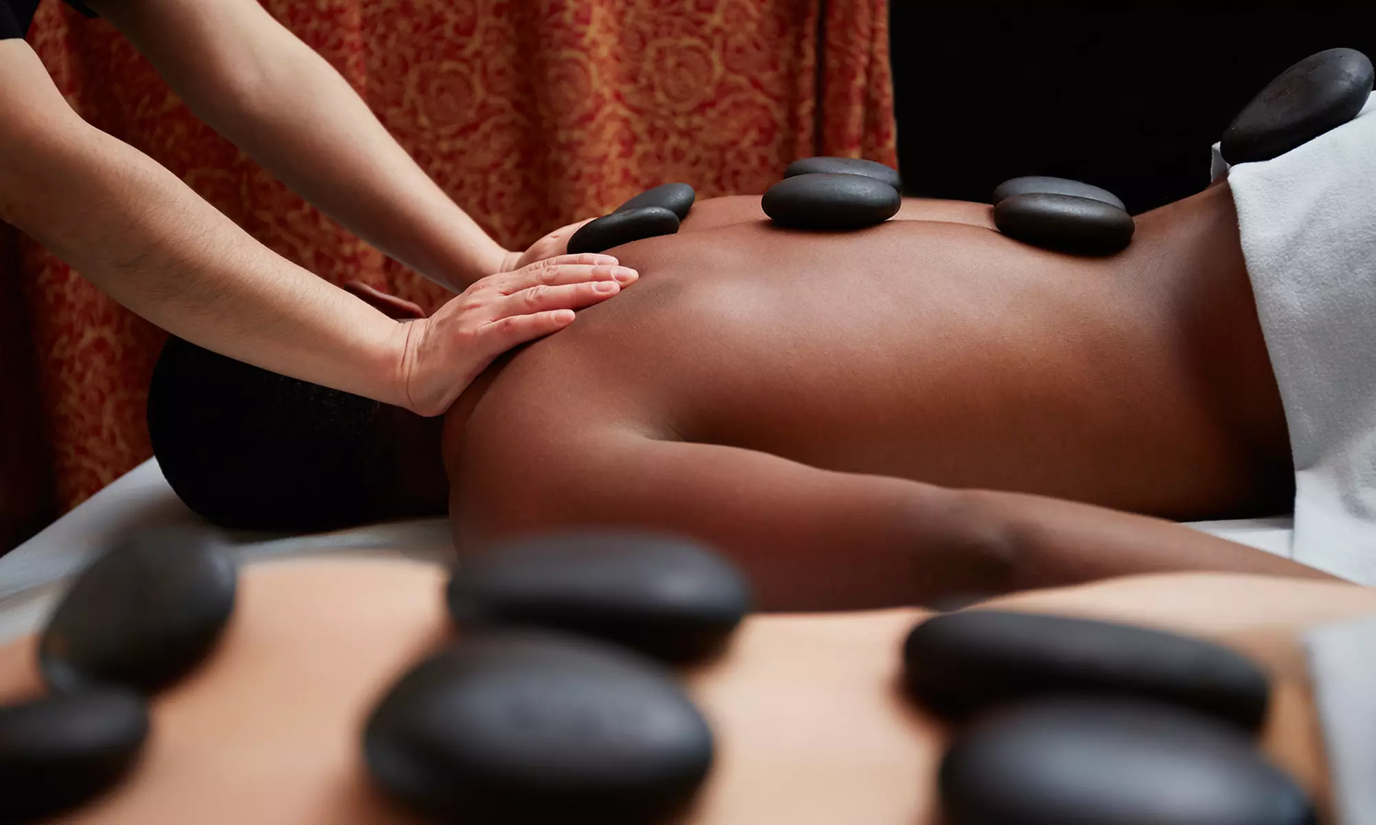 One, Three, or Five Hot-Stone Massages or One Couples Hot-Stone Massage at Rejuvenations Spa (Up to 60% Off) - Primary Image