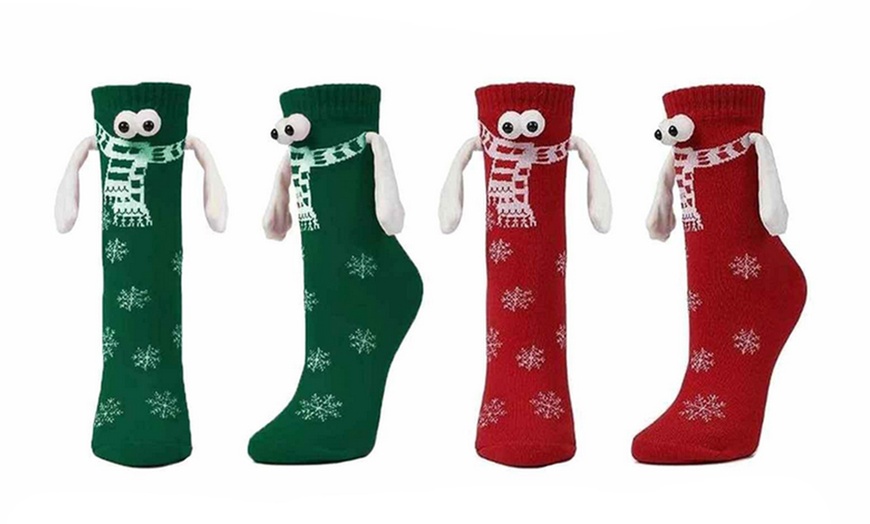 Image 1: Two-Pairs of Christmas Novelty Magnetic Couple Holding Hands Socks