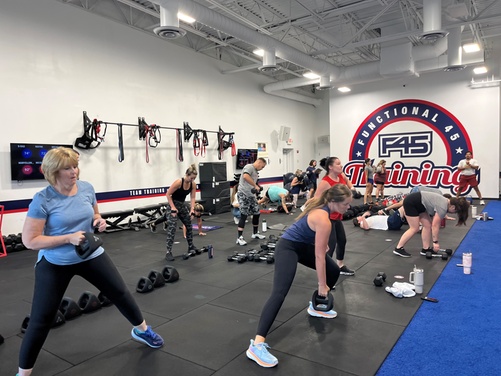 A group of people engaged in a high-energy F45 circuit training class.