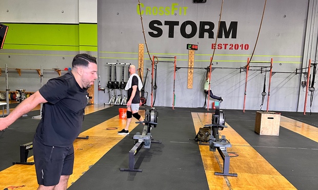 People working out in a spacious, modern CrossFit gym.