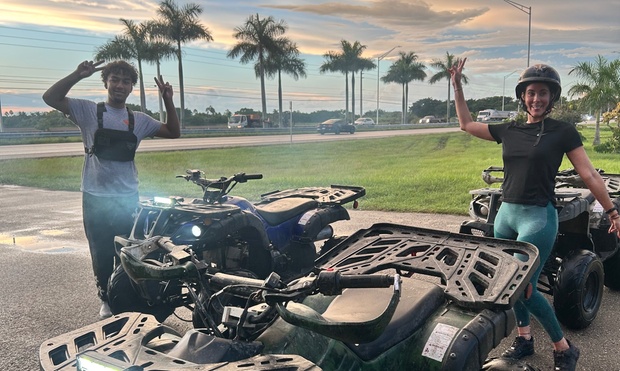 People riding ATVs on a scenic trail in the Miami countryside.