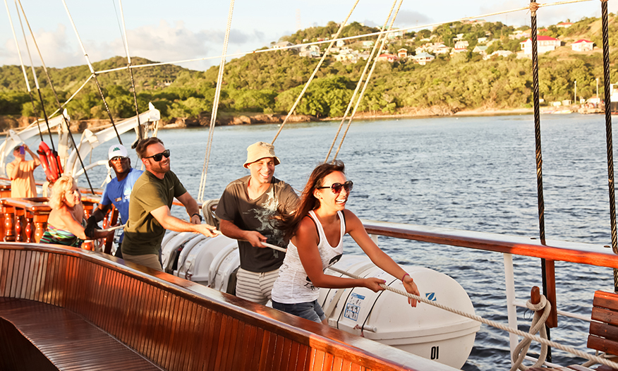 Cruise passengers helping to hoist the sails