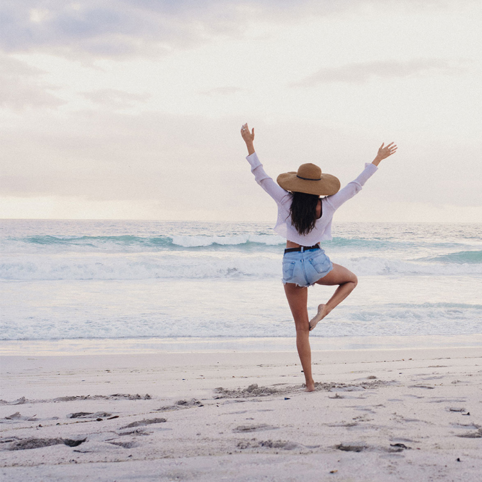 woman on the beach doing yoga