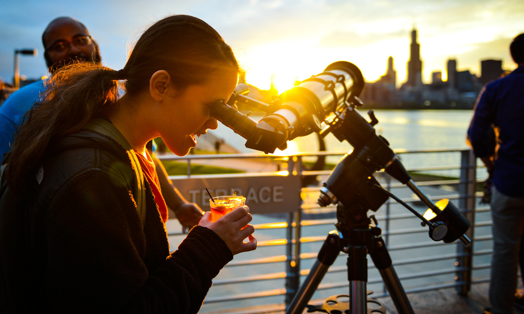 Woman looking through telescope at Adler Planetarium
