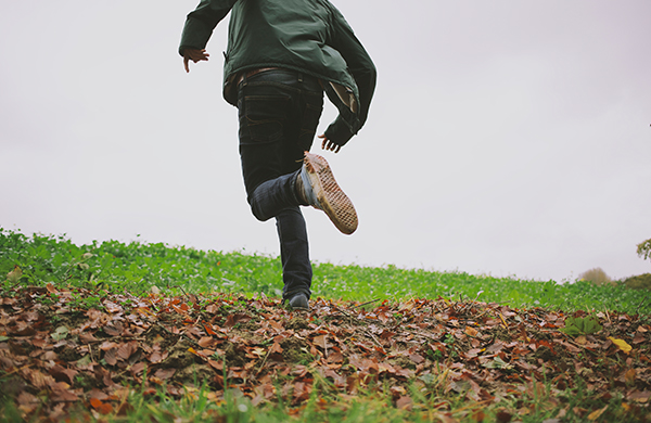 person running through field with fall autumn leaves 1 jpg