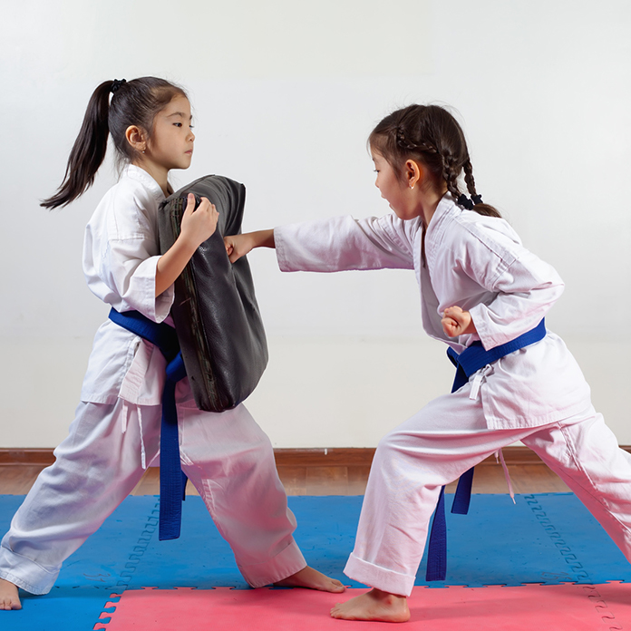 Girls with blue belts doing martial arts