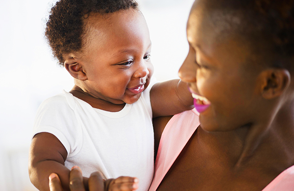 Smiling mother holding smiling baby