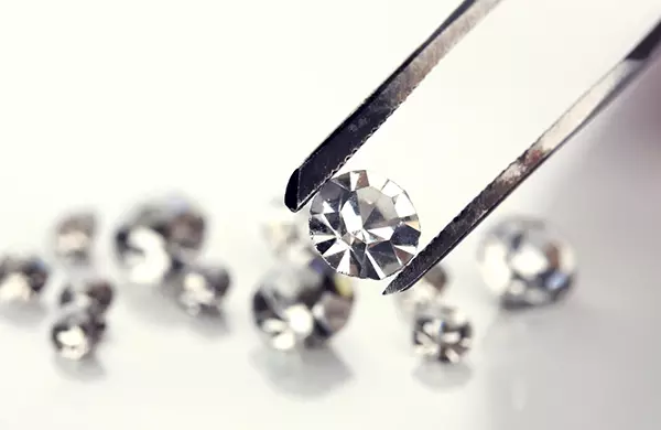 Technician holding lab-grown diamond with jeweler's tongs