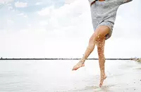 woman in short shorts kicking water