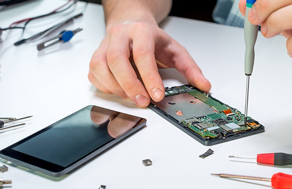 Caucasian man repairing mobile cell phone circuit board