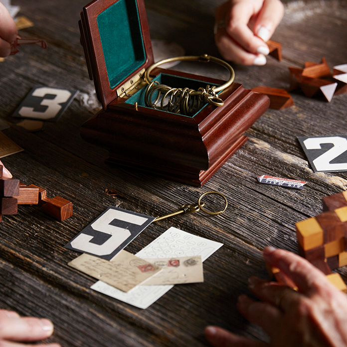 Closeup of people trying to solve escape room puzzles