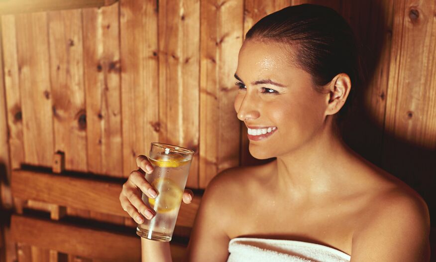 woman drinking water in sauna
