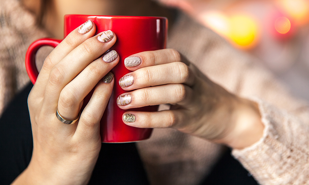 woman with winter nails designs holding mug
