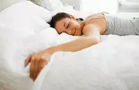 woman smiling lying face-down on mattress