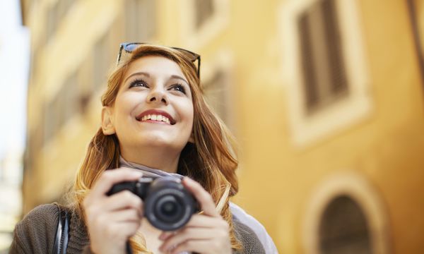 Happy woman alone with camera