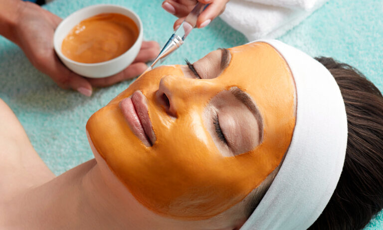 Beautiful woman getting a pumpkin mask