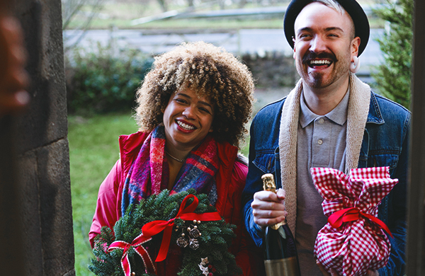 man and woman welcomed guests with christmas gifts jpg