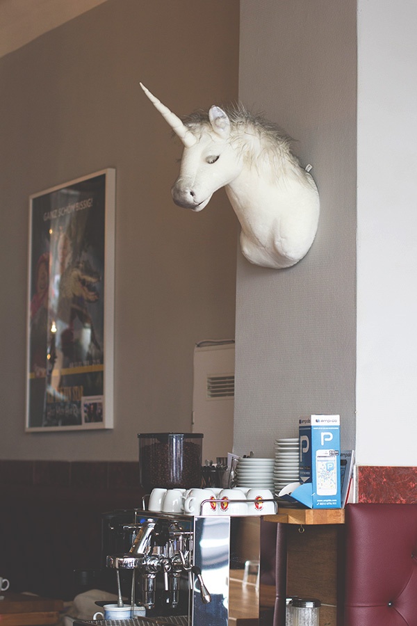 Blick auf die Espressomaschine und den Einhornkopf an der Wand