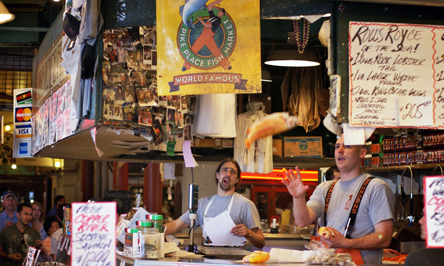 Guys tossing fish at fish market