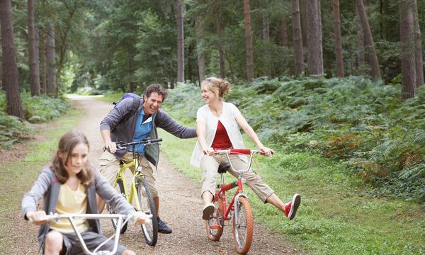 Family riding bikes on nature trail